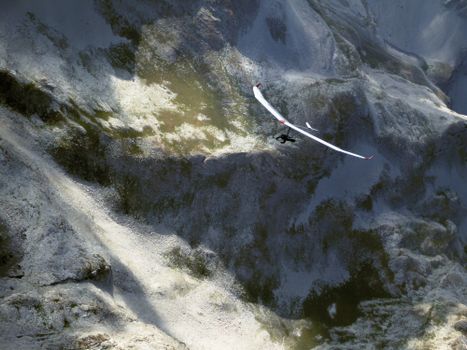Soaring paraglider over the rugged peaks of Seyne, France, capturing breathtaking freedom.