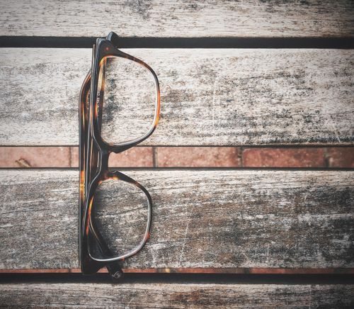 Free Tortoiseshell glasses placed on a rustic wooden table top view, scenic and detailed. Stock Photo