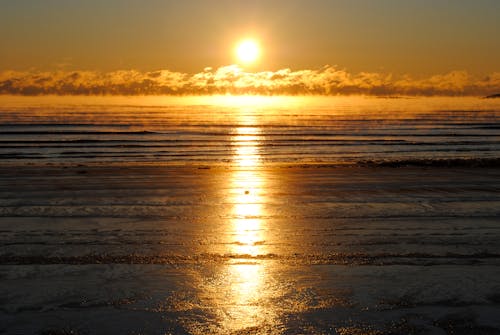 Amazing view of bright setting sun shining over endless waving sea in tranquil nature