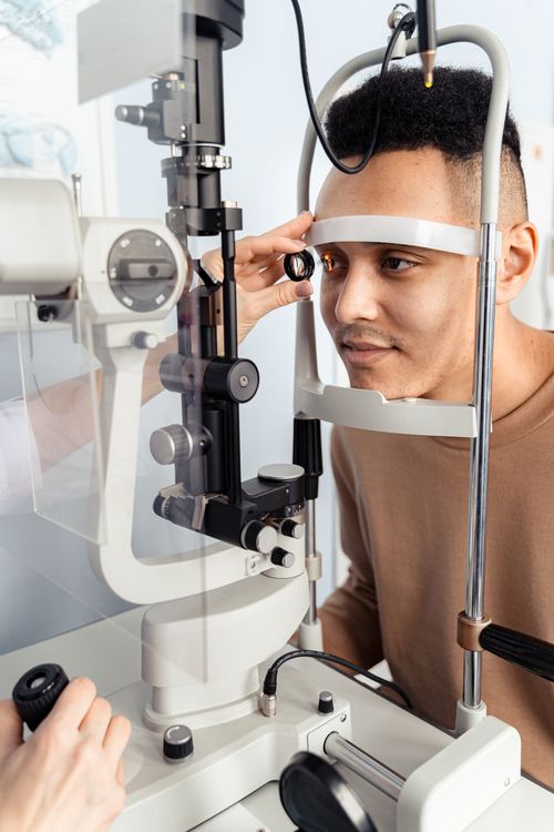 Free Man having an eye exam using a slit lamp, focusing on detailed ocular inspection. Stock Photo
