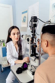 Optometrist examines patient using slit lamp for eye health assessment. Indoors clinic setting.
