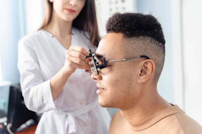 Homem usando armação de provas durante consulta optométrica