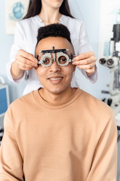 Free Doctor Putting an Optical Trial Lens Frame on a Patient Stock Photo