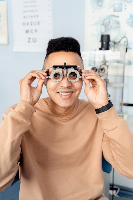 Man smiling while holding trial frames during an eye exam at an optometrist's office.
