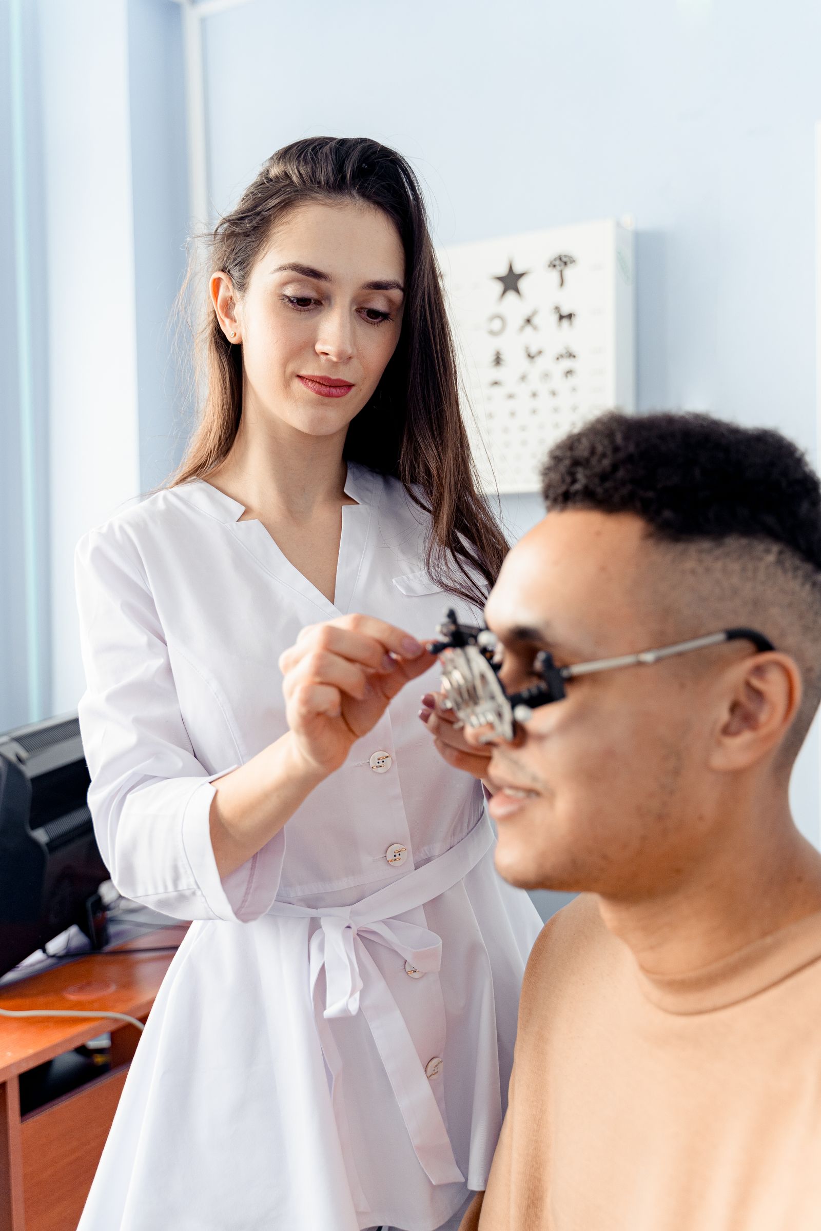 Optometrist adjusting trial lenses during a refractive eye examination