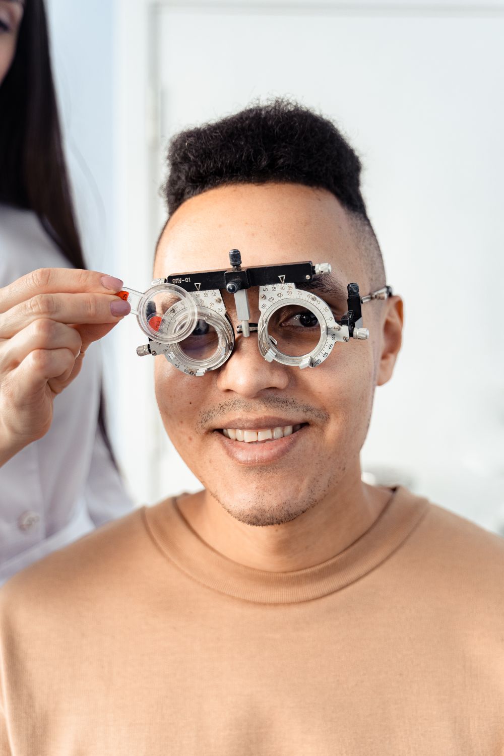 Smiling patient wearing a trial frame during an eye test