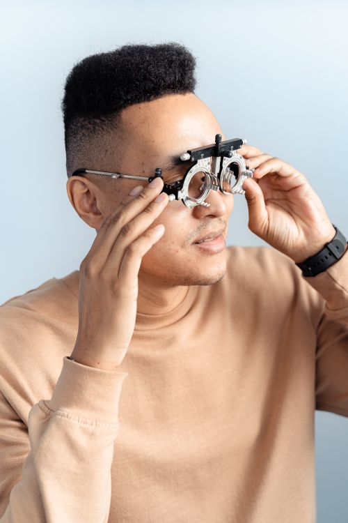 Free Adult man wearing a trial frame for an eye examination, dressed in a casual sweatshirt. Stock Photo