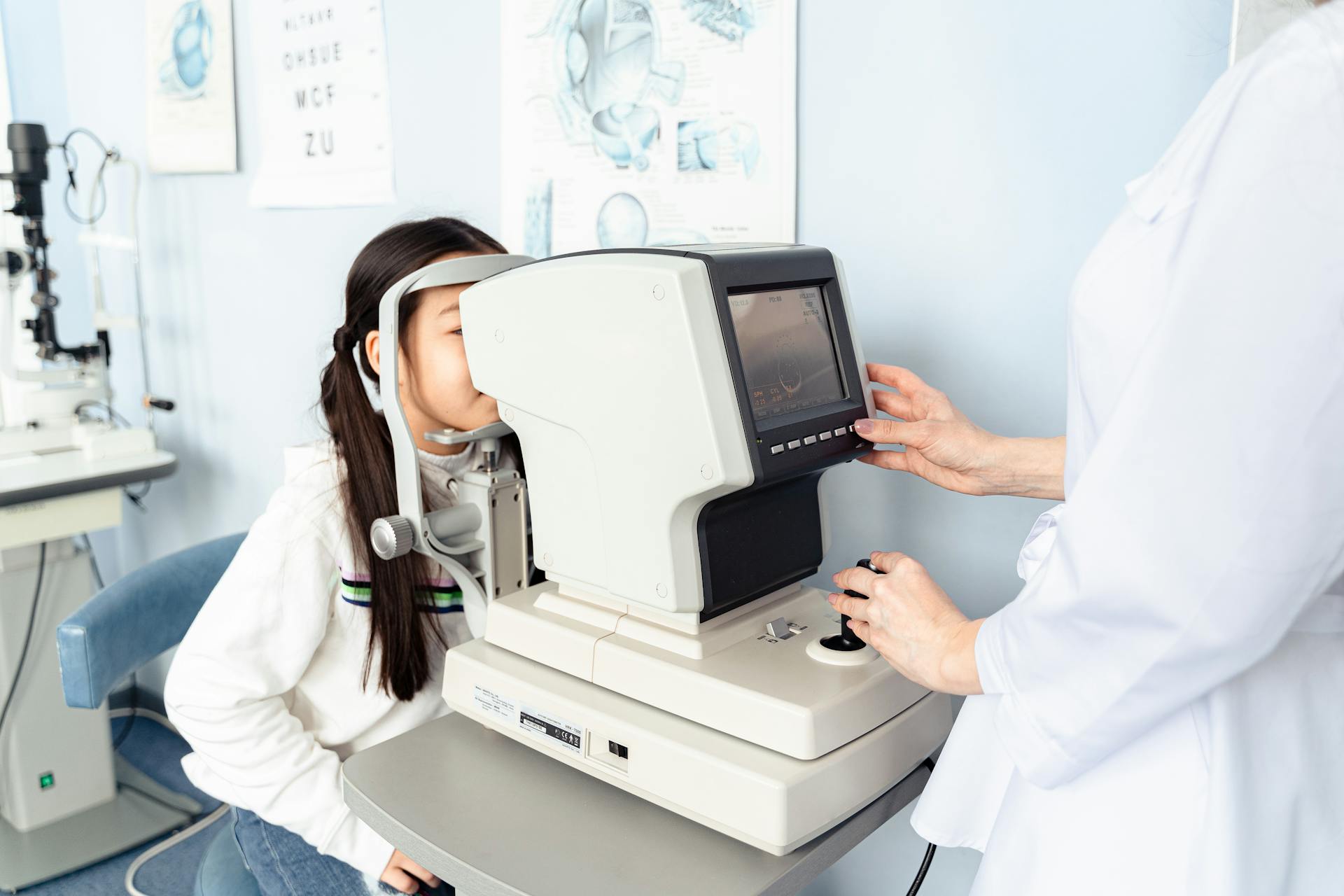 A child undergoing an eye exam in a modern optometry clinic with a professional optometrist.