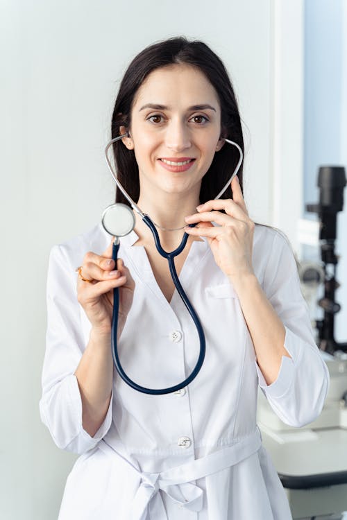 Free Woman Smiling while Holding a Stethoscope  Stock Photo