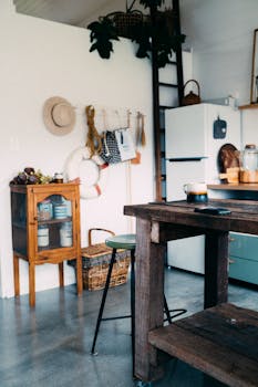 A charming rustic kitchen interior featuring a wooden table, ladder shelf, and wall decor.