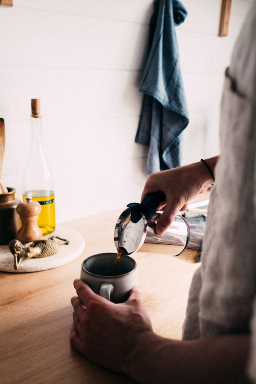 Free Person Pouring Coffee on a Mug Stock Photo