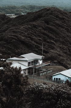 Charming modern house nestled in lush mountain landscape, showcasing rural tranquility.
