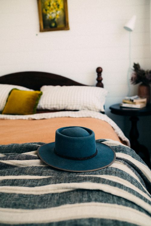 Free Inviting bedroom setting with a blue hat on the bed, ideal for cozy home decor themes. Stock Photo
