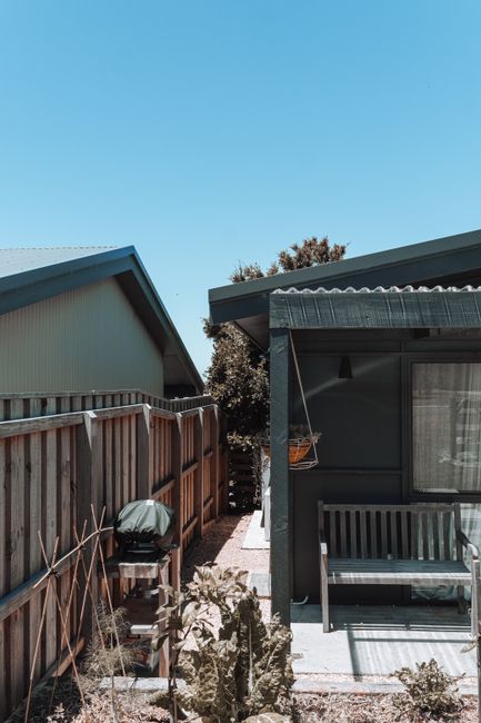 Photo by Rachel Claire on Pexels Sunny backyard featuring a wooden fence and bench. Ideal for outdoor relaxation and living.