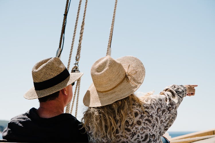 Back View Of A Couple Wearing Sun Hats