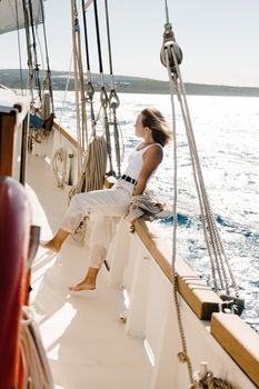 A woman relaxing on a sailboat, enjoying a sunny voyage on the open sea.