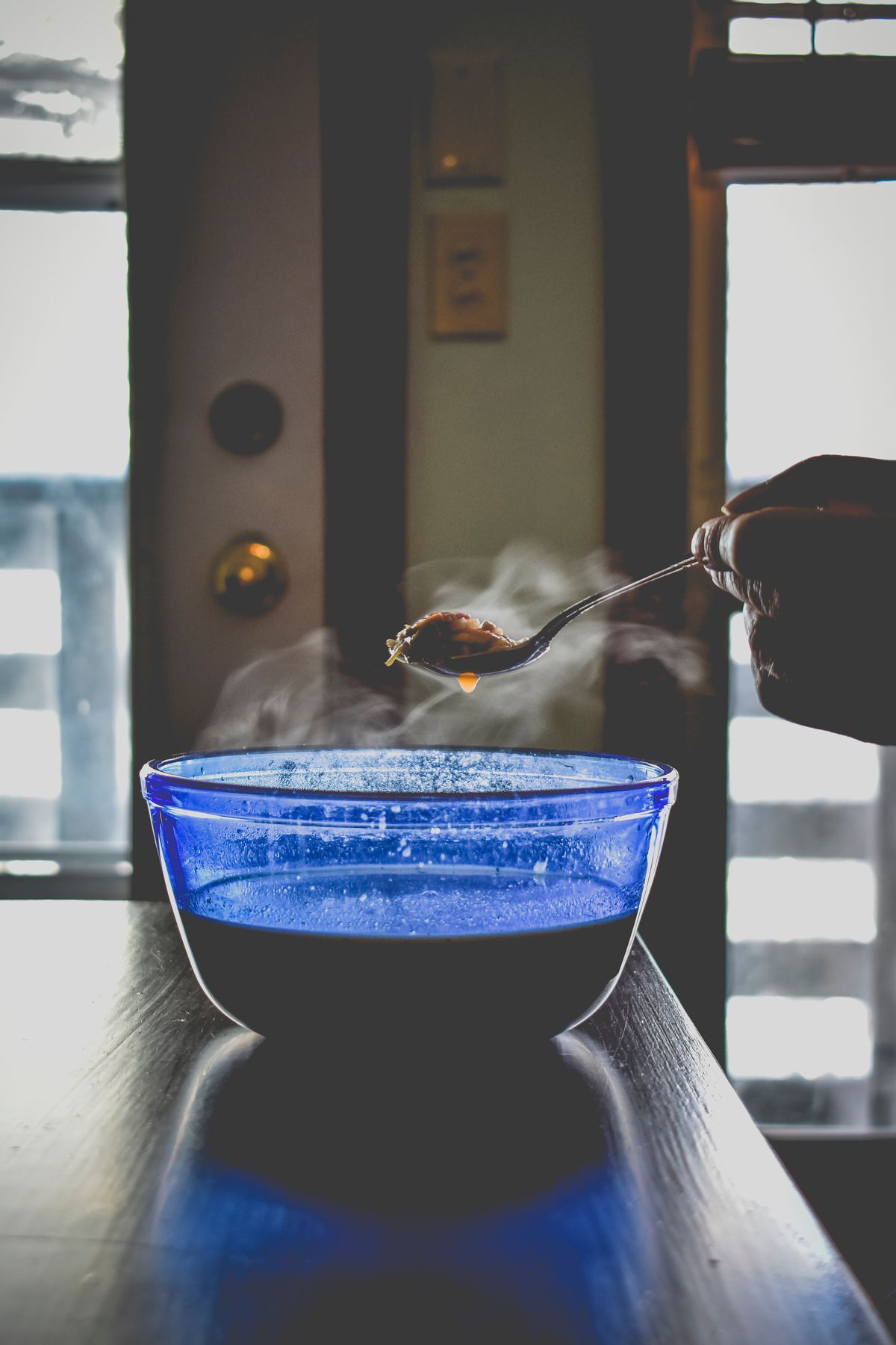Person lifting a spoonful of hot broth from a bowl, illustrating a daily bone broth habit within a wider gut health routine