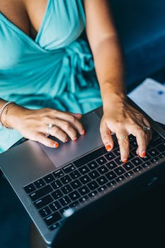 Overhead view of a woman typing on a laptop, showcasing modern remote work lifestyle.