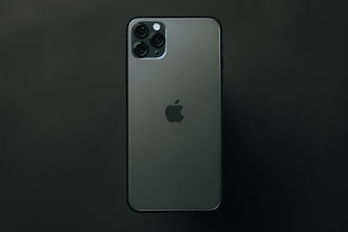 Free From above modern expensive smartphone with high quality cameras placed on dark surface Stock Photo