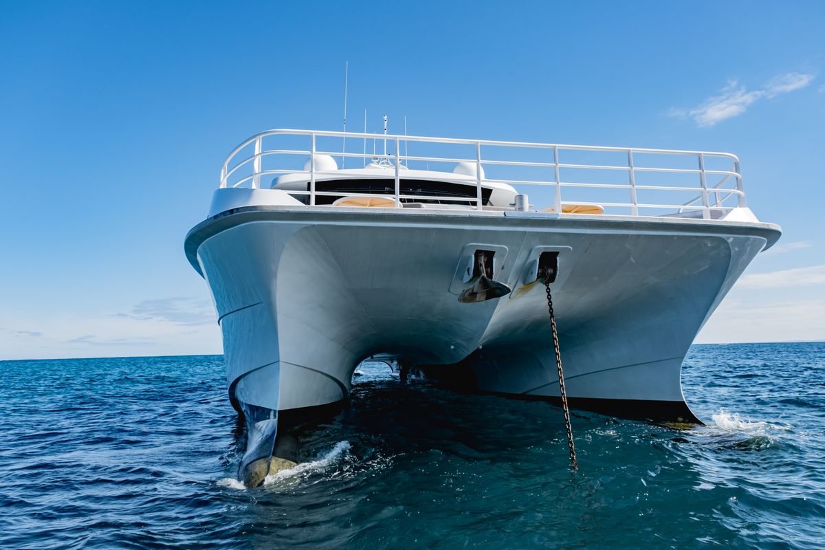 Étrave d'un catamaran au mouillage, mer calme
