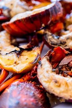 Delicious grilled lobster tails with lemon slices, perfect for seafood lovers.