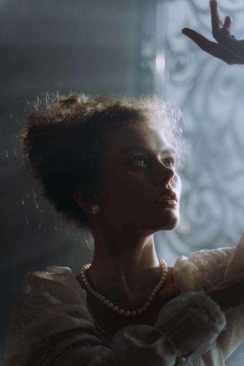 Free A captivating portrait of a woman in elegant attire, bathed in soft natural light. Stock Photo