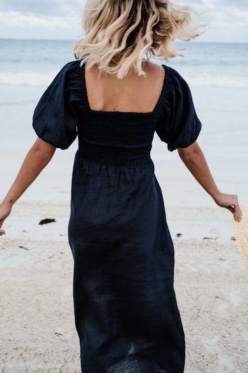 Free A Woman Wearing a Black Dress at the Beach Stock Photo