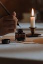Person dipping Quill Pen in an Ink