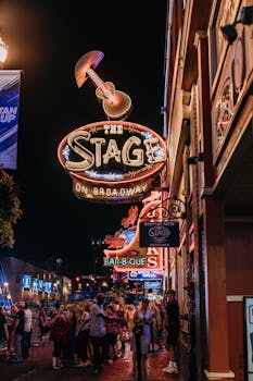 Dynamic nightlife scene at The Stage on Broadway featuring neon lights and bustling crowds.