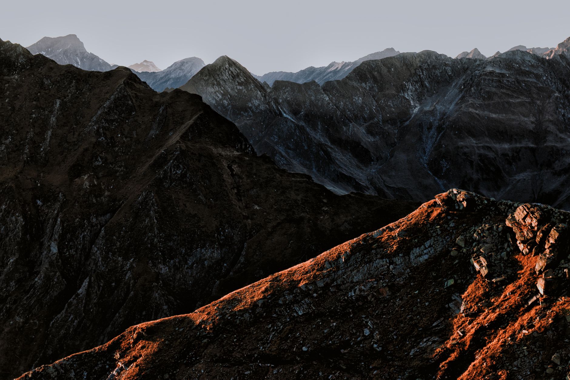 Stunning view of a mountain range at sunset with dramatic lighting and rocky terrain. — free online jigsaw puzzle on JigsawPuzzlesFreeOnline.org