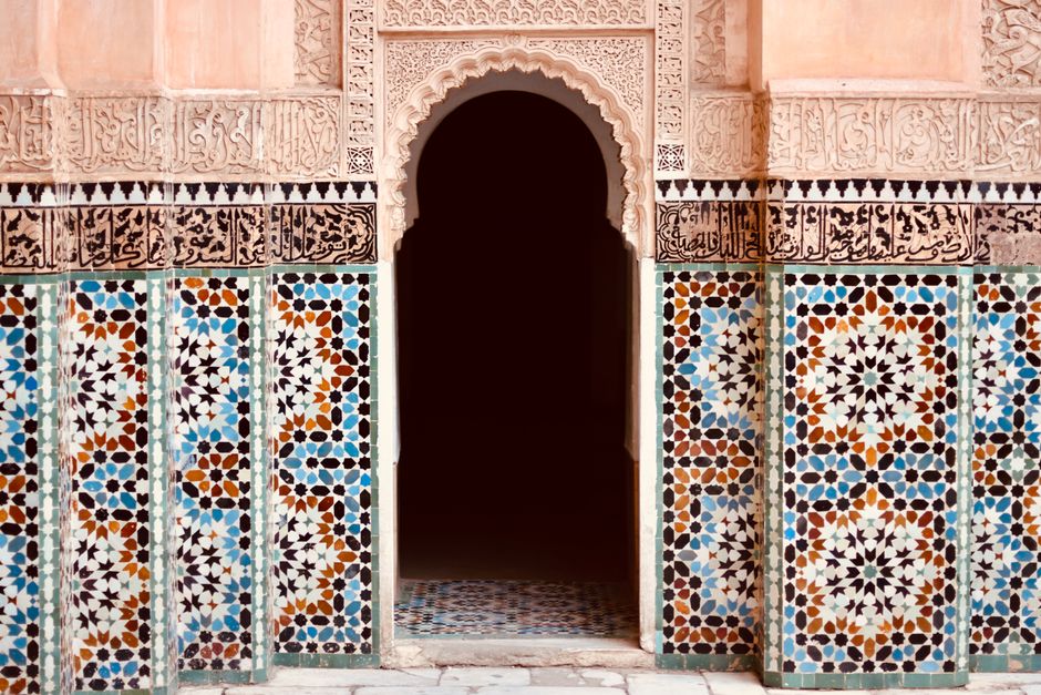 Beautiful Islamic architecture in Marrakesh featuring ornate mosaics and an arched entrance.