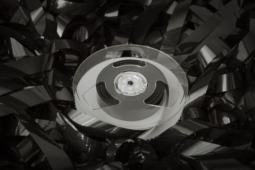 Close-up of a vintage cassette reel surrounded by tangled tape, evoking nostalgia and retro vibes.
