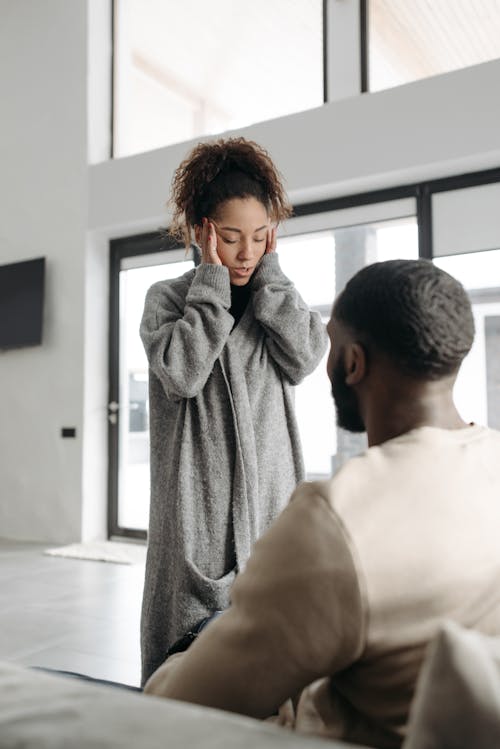 Woman Touching Her Head In Front Of A Man