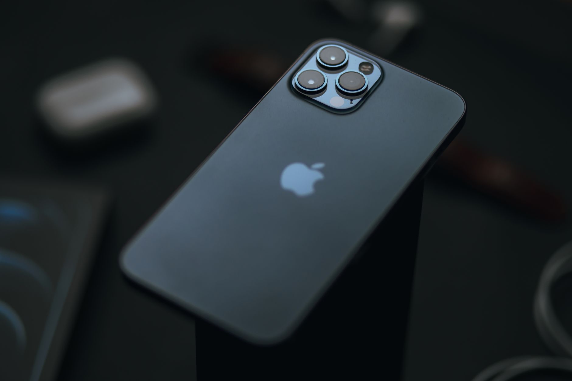 High angle of modern expensive smartphone placed against blurred dark background in studio