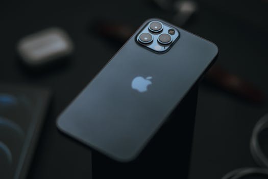 Close-up shot of a modern smartphone with triple cameras on a black surface, emphasizing luxury and minimalism.