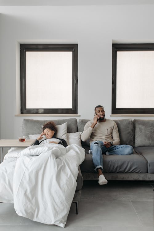 Free Man And Woman Resting On A Sofa Stock Photo