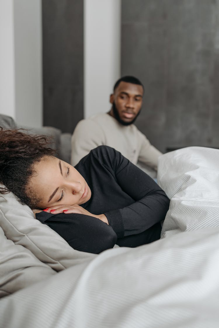 Man Looking At Sleeping Woman