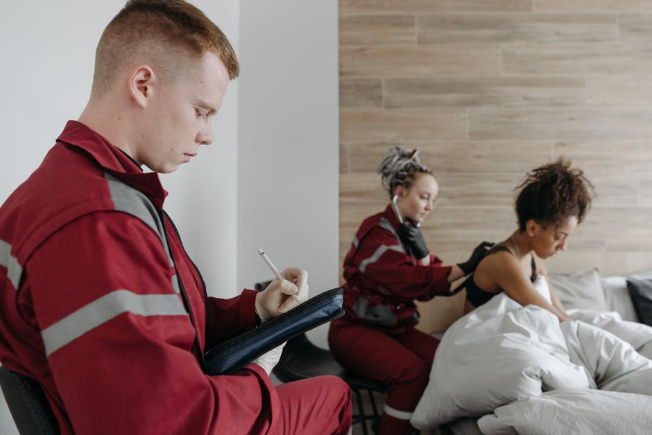 Paramedics providing medical care to a patient at home, showcasing healthcare services.
