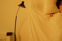 A woman lying awake in bed at 3:33 a.m., showcasing insomnia issues.