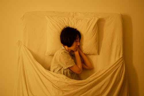 Free A Sad Woman Lying on the Bed Stock Photo