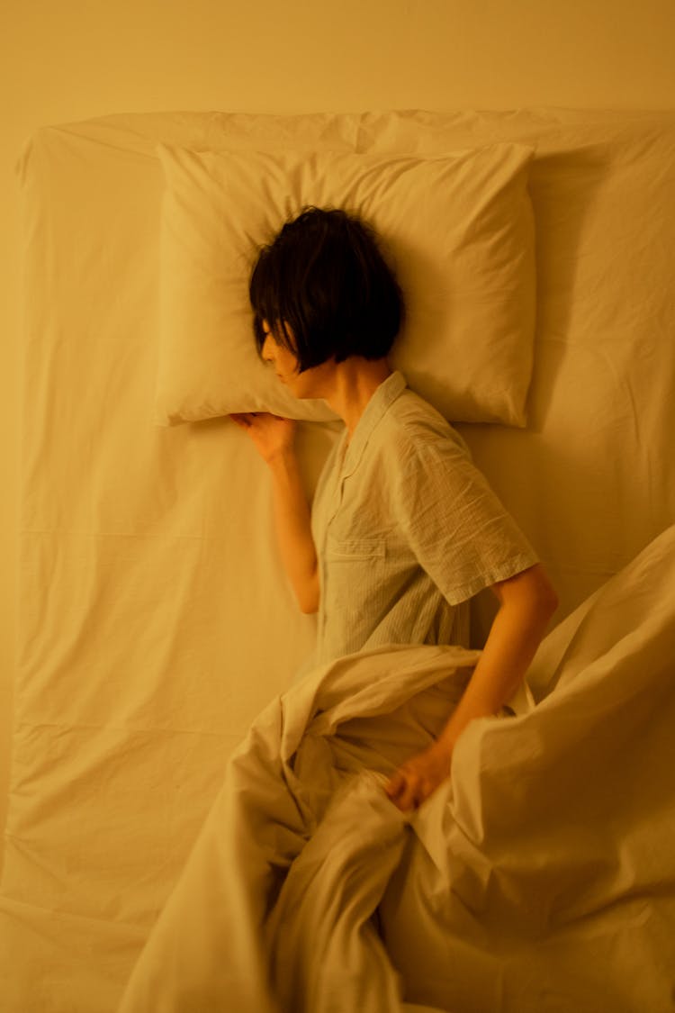 A Person In Pajama Lying On The Bed