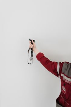 Emergency medical professional holding a stethoscope against a plain white background.