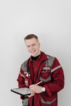 Cheerful paramedic in uniform holding a clipboard and smiling.