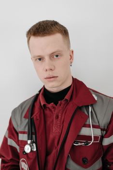 A focused young medical professional in uniform with a stethoscope indoors.