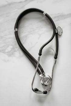 Professional-grade stethoscope on a white marble background, ideal for medical themes.