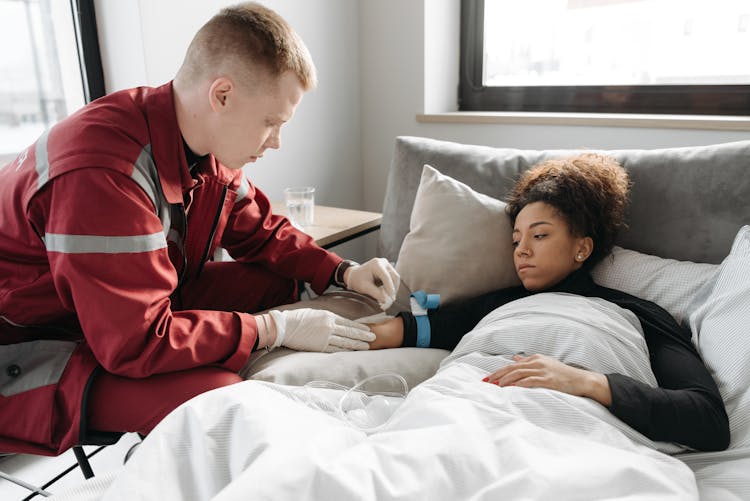 EMT Inserting A Needle On Woman's Arm