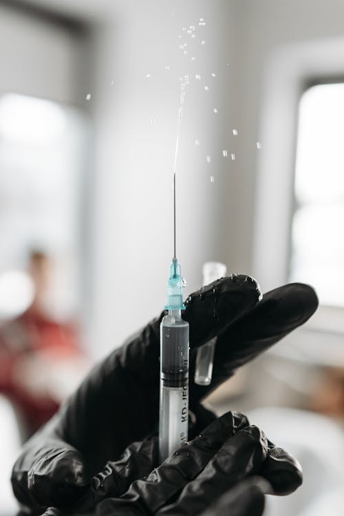 Free Person Holding A Syringe Stock Photo