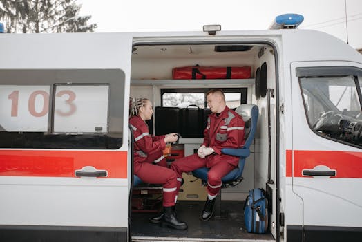 Paramedics in uniform inside an ambulance, ready for emergency response.