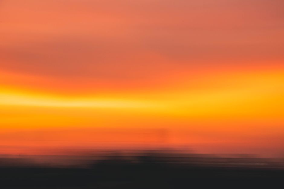 Abstract view of an orange sunset above the ocean, showcasing vibrant hues.