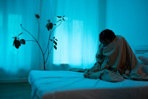 Free A Lonely Woman Sitting on the Bed Stock Photo